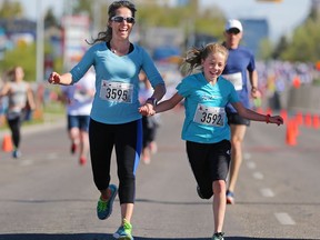 Ava Shaw, 12, holds hands with her mom Stephanie at the finish line of the Sport Chek Mother's Day Run and Walk at Chinook Centre in 2017. The event supports neonatal units in Calgary as well as Jumpstart for Kids. Gavin Young/Postmedia Network