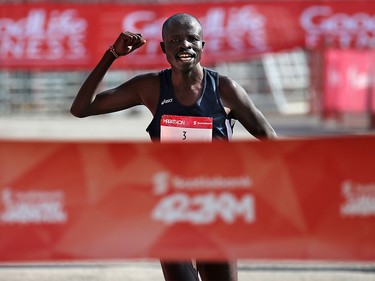 Jonathan Chesoo of Kenya raises his fist as he wins the men’s division of the Scotiabank Calgary Marathon on Sunday May 26, 2019. Chesoo finished the race in 2:19:33.