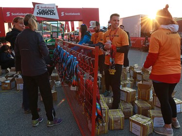 Race volunteers prepare finisher medals as the sun rises before the Scotiabank Calgary Marathon at Stampede Park on Sunday May 26, 2019.