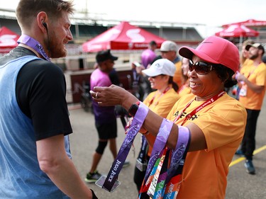 Volunteers hand out finisher medals at the Scotiabank Calgary Marathon on Sunday May 26, 2019.