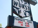 A sign for Wurst Restaurant in Calgary's Mission district shows the increase in its property taxes.