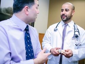 Dr. Nathan Thakur, right, discusses the importance of preventative care for male patients over 40.