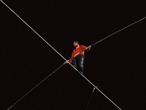 Daredevil Nik Wallenda walks on a tightrope uphill at a 19-degree angle from the Marina City west tower across the Chicago River to the top of the Leo Burnett Building in Chicago, Sunday, Nov. 2, 2014.