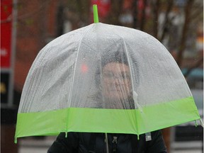 Marlene Paulson walks in the rain on Kensington Rd NW in Calgary on Friday, May 17, 2019. Umbrellas will be necessary over the next few days as the long weekend weather forecast calls for rain. Jim Wells/Postmedia