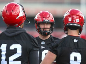 Stampeder QB Bo Levi Mitchell (C) chats with fellow QBs Montell Cozart (L) and Nick Arbuckle during the first session of Calgary Stampeders CFL training camp in Calgary Sunday, May 19, 2019. Jim Wells/Postmedia