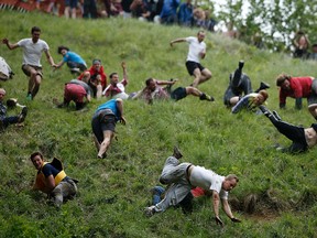 Competitors tumble down Cooper's Hill near Gloucester, England in pursuit of a wheel of Double Gloucester.