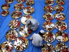 Muslim men prepare plates before breaking day-long fast during the holy month of Ramadan in Mumbai, India, May 16, 2019.