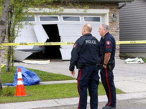 A garage door is blown out at a home in Kincora where two people were found dead on Saturday, May 25, 2019. Calgary homicide detectives are investigating.