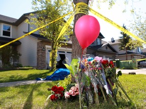 A memorial grows outside a home on Kincora Drive N.W. where police investigators were still on the scene Monday, May 27, 2019. Two people were found dead inside the house and a young woman was seriously injured after an explosion and fire on Saturday.