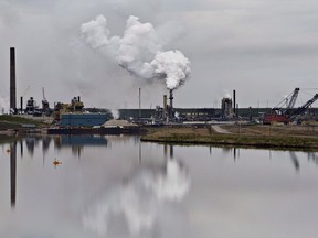 The Syncrude oilsands extraction facility is reflected in a tailings pond near the city of Fort McMurray on June 1, 2014.