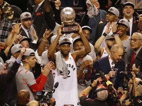 Toronto Raptors Kawhi Leonard raises the Eastern Conference champions trophy in Toronto on Saturday, May 25, 2019.