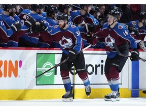 Colorado Avalanche left wing J.T. Compher, front left, is congratulated after scoring a goal as he passes the team bench with defenceman Nikita Zadorov in the second period of Game 6 of an NHL hockey second-round playoff series against the San Jose Sharks, Monday in Denver.