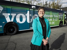 Returning Officer Barb Clifford mugs for a photo with a city bus, aka a soon-to-be mobile advance-voting station, at Calgary Transit's northeast headquarters in Calgary, Alta., on Tuesday October 1, 2013. Buses will act as advance voting stations from Oct. 9 to 16 at 10 stations around the city. Lyle Aspinall/Calgary Sun/QMI Agency