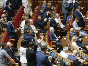 Ukraine's lawmakers react during a parliament session in Kiev, Ukraine, Wednesday, May 22, 2019. Party leaders at Ukraine's parliament have rebelled against the new president's decision to disband parliament and ignored his call to amend the election law. The face off between Volodymyr Zelenskiy, who was sworn in on Monday, and the Supreme Rada came a day after parliament leaders sat down with the president and publicly supported his initiatives including holding snap elections under new rules.