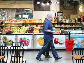 Customers walk in front of a grocery outlet at Eau Claire Market in downtown Calgary. The redevelopment of the Eau Claire area has been a topic of discussion for decades.