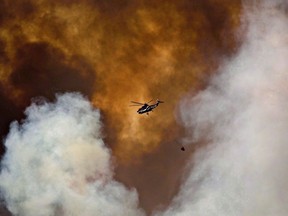 A helicopter battles a wildfire in Fort McMurray on May 4, 2016. Officials say the wildfire danger is already high to extreme in areas of Western Canada.