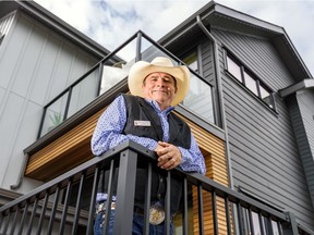 Edward Gordon, Calgary Stampede Lotteries Committee Chair, poses in front of the 2019 Rotary Dream Home.