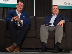 Saskatchewan Premier Scott Moe, left, applauds a joke made by Alberta Premier Jason Kenney during the Saskatchewan Oil & Gas Show held at the Crescent Pointe Centre in Weyburn.