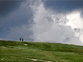 Walkers on Nose Hill saw both sun and storm with unsettled spring weather on Sunday, June 23, 2019.  Gavin Young/Postmedia