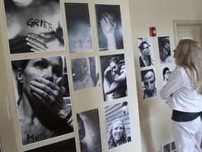 Visitors tour The Uncommon Woman black and white photo exhibit at McHugh House in Calgary on Tuesday June 25, 2019. The exhibit is made up of self portraits of women who have also written words on their bodies. Gavin Young/Postmedia