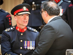 Calgary's new chief of police Mark Neufeld shakes hands with Mayor Naheed Nenshi during the Change of Command ceremony at the Calgary Central Library on Monday, June 10, 2019.