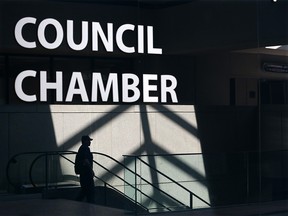 Pedestrians at City Hall are reflected in the glossy wall of Council Chambers as they walk past on Monday June 3, 2019.