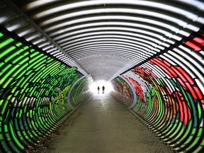 Pedestrians walk through the artwork recently painted on the tunnel connecting Confederation Park under 10th Street N.W. on Wednesday June 5, 2019. Gavin Young/Postmedia