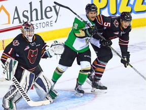 The Calgary Hitmen's Jackson van de Leest and Prince Albert Raiders forward Brett Leason fight for position next to Hitmen goaltender Carl Stankowski during WHL action in Calgary on Monday October 8, 2018. Gavin Young/Postmedia