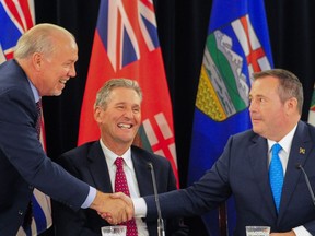 Alberta Premier Jason Kenney shakes hands with British Columbia Premier John Horgan at the closing of the Premiers' Conference in Edmonton on Thursday.