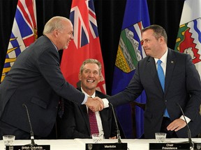Alberta Premier Jason Kenney (right) shakes hands with B.C. Premier John Horgan as Manitoba Premier Brian Pallister looks on after the conclusion of a meeting of the western premiers Thursday, June 27, 2019.