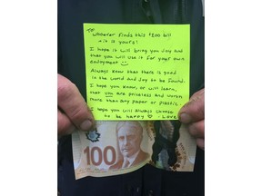 A person holds a $100 dollar bill and a note in this undated handout photo. A Nova Scotia community has been warmed by an anonymous gesture from a stranger who placed $100 bill and a message of positivity in a town park. The treasure was found by New Glasgow town employee Doug Miller while setting up for a funding announcement over the weekend.