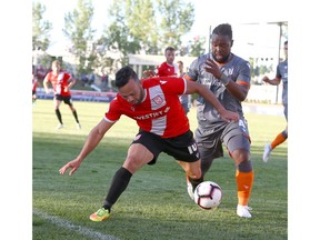 Cavalry FC's Jose Camargo is challenged by Forge FC Dominic Samuel during first-half CPL Action between the two teams at ATCO Field at Spruce Meadows on Tuesday. Cavalry FC won 2-1. Photo by Jim Wells/Postmedia.