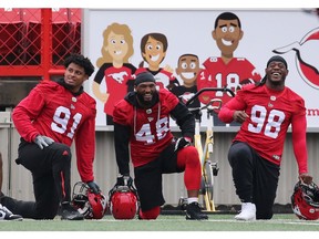 The smiles from Calgary Stampeders from left; Mike Rose, Wynton McManis and Ese Mrabure mirror a sidelines banner during team practise at McMahon Stadium in Calgary, Thursday June 27, 2019.  Gavin Young/Postmedia