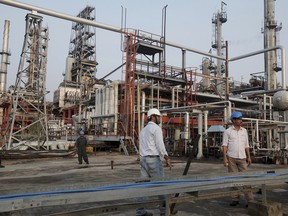 Laborers work at the Numaligarh Refinery Ltd. complex in Golaghat, India.