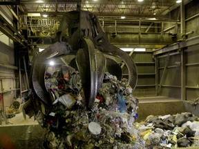 Garbage is dropped from a grappler into a hopper, where it will be fed into a combustion chamber and incinerated at the Vancouver Waste-To-Energy garbage facility in Burnaby.