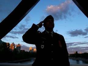 Capt. Brad Young of the 41 Brigade Group salutes during the Breakfast on the Bridge fundraising event held on the Peace Bridge at sunrise in Calgary, Alta on Saturday June 20, 2015. Jim Wells/Postmedia Calgary