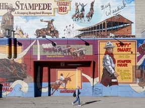 A man walks by a mural on the Stampede Grounds in Calgary, Alta., on Friday, March 6, 2015. Shot for archives. Lyle Aspinall/Calgary Sun/QMI Agency