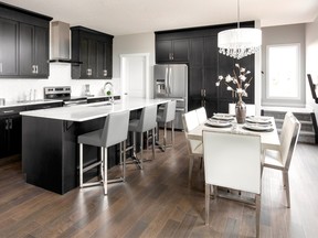 The Jade by Trico Homes in Redstone is 2,208 square feet with the kitchen featuring stainless steel appliances and dark cabinets.