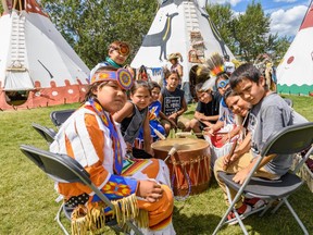 The Little Guys, an indigenous group of drummers between the age of 6-15 from the Tsuu T'ina Nation pose for a photo in front of their tipi at the Elbow River Camp on Friday, July 12, 2019. Azin Ghaffari/Postmedia Calgary