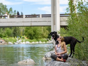 Robin Locke and her dog Penny enjoy the sunny weather by the Bow River Pathway on Monday, July 22, 2019. Azin Ghaffari/Postmedia Calgary
