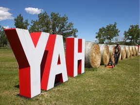 Jessy Peoples trims the grass around a sign near the Mountain View Campground on the eastern edge of Calgary recently.