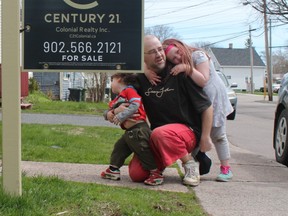 Jeff Gallant crouches with his children outside his rental unit in Charlottetown, two weeks before receiving an eviction notice.