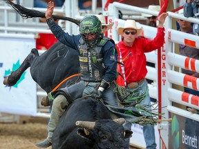 Arkansas cowboy Chase Outlaw hangs on for a 90-point ride on Rhythm & Blues during the bull-riding event at the Calgary Stampede rodeo on Monday, July 8, 2019.