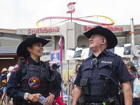 Calgary police Cst. Colin Thorne and Blood Tribe police Cst. Hadiga Little Wolf walk the Stampede grounds on Tuesday, July 10, 2019.