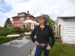 Sal Howell, proprietor at The Deane House, poses at the property in southeast Calgary on Tuesday, July 9, 2019. The Hunt House on the right, built in 1876, and the Deane House, built in 1906, are in a part of Calgary which is rich in culture, history and the spirit of Calgary. Jim Wells/Postmedia