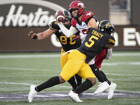 Calgary Stampeders quarterback Nick Arbuckle (9) is sacked by Hamilton Tiger Cats defensive end Adrian Tracy (5) during first half CFL football game action in Hamilton, Ont., on Saturday.