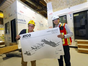 Murray Marshall (L), dad of Sapper Steven Marshall who died on Oct. 20 2009, while on foot patrol in Panjwai district in Kandahar province, Afghanistan and Moy Wornovitzky, IT, Marketing and Corporate Services ATCO hold up the plans to the Homes for Heroes project.