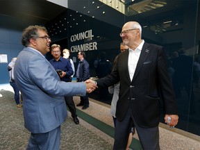 Mayor Naheed Nenshi and Flames boss Ken King shake hands as council voted for a new arena in Calgary on Tuesday, July 30, 2019.
