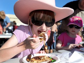 Megan Christen, 7, tucks into a pile of pancakes at the CF Chinook Centre stampede breakfast on July 7, 2018.