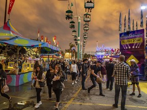 Storm clouds gather over the midway at the Calgary Stampede on Friday, July 6, 2019.